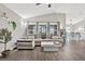 Bright living room showcasing vaulted ceiling, wood-look flooring, modern furnishings, and ample natural light at 13111 Fruitville Way, Riverview, FL 33579