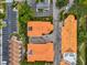 An aerial view of condos featuring terra cotta roofing, mature trees, and a parking area for residents and guests at 1340 Bayshore Blvd # 502, Dunedin, FL 34698