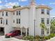 Beautiful exterior view of a three-story Mediterranean style townhome, featuring a garage and red SUV at 1340 Bayshore Blvd # 502, Dunedin, FL 34698