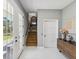Bright foyer featuring modern tile, glass panel doors, staircase, and decorative table at 1340 Bayshore Blvd # 502, Dunedin, FL 34698