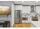 Modern kitchen with stainless steel refrigerator, white cabinets, and hardwood floors at 1340 Bayshore Blvd # 502, Dunedin, FL 34698