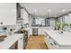 Modern kitchen featuring white cabinets, stainless steel appliances, an island, and hardwood floors at 1340 Bayshore Blvd # 502, Dunedin, FL 34698