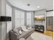 Comfortable living room featuring a cozy sofa, ottoman, bay windows with shutters, and modern decor at 1340 Bayshore Blvd # 502, Dunedin, FL 34698