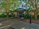 Dunedin Highlander Pool building exterior, surrounded by lush greenery and mature trees at 1340 Bayshore Blvd # 502, Dunedin, FL 34698