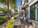 Outdoor seating area with tables, chairs, and lush landscaping lining a commercial building under a sunny sky at 1340 Bayshore Blvd # 502, Dunedin, FL 34698