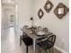 Modern dining area featuring a sleek metal table, black seating, and decorative wall mirrors near the entryway at 135 Mangrove Shade Cir, Apollo Beach, FL 33572