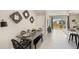 Modern dining area featuring a sleek metal table, black seating, and decorative wall mirrors, adjacent to a living area at 135 Mangrove Shade Cir, Apollo Beach, FL 33572