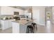 Open-concept kitchen with stainless steel appliances, granite countertops, an island with seating, and white cabinetry at 135 Mangrove Shade Cir, Apollo Beach, FL 33572