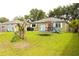 Spacious backyard with lush green grass, patio, and play equipment at 1423 Birchstone Ave, Brandon, FL 33511