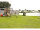 Spacious backyard with fun playground equipment and great views of the lake, perfect for Gathering activities at 1423 Birchstone Ave, Brandon, FL 33511