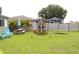 Spacious backyard with lush green grass, patio, and play equipment at 1423 Birchstone Ave, Brandon, FL 33511