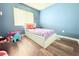 Bright bedroom with a window, laminate floor, and white bedframe with storage drawers at 1423 Birchstone Ave, Brandon, FL 33511