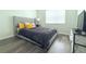 Bright bedroom with laminate floor, a window, and a queen bed with upholstered headboard at 1423 Birchstone Ave, Brandon, FL 33511