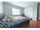 Bedroom with wood floor, a closet, and a large bed in front of a window at 1423 Birchstone Ave, Brandon, FL 33511