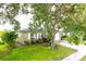 Exterior elevation of a one story home shows a well manicured lawn, mature trees and an attached one car garage at 1423 Birchstone Ave, Brandon, FL 33511