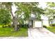 Exterior elevation of a one story home shows a well manicured lawn, mature trees and an attached one car garage at 1423 Birchstone Ave, Brandon, FL 33511