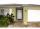 Close up of front entrance showing the front door, attached one car garage and well-manicured landscaping at 1423 Birchstone Ave, Brandon, FL 33511