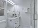 A modern and bright bathroom with granite counters, black fixtures, a glass shower, and marble floors at 1506 Winding W Way, Clearwater, FL 33764