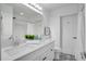 A modern and bright bathroom with a double sink granite vanity, a toilet, and black and white tile flooring at 1506 Winding W Way, Clearwater, FL 33764