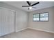 Sun-filled bedroom with a ceiling fan, large window, and light gray walls and luxury vinyl plank flooring at 1506 Winding W Way, Clearwater, FL 33764