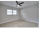 A sun-filled bedroom with a ceiling fan, light gray walls, and a large window with black blinds at 1506 Winding W Way, Clearwater, FL 33764
