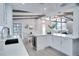 Bright modern kitchen with white countertops and stainless appliances, opens to living area at 1506 Winding W Way, Clearwater, FL 33764