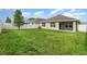Large grassy backyard featuring a patio, privacy fence and mature trees at 15406 Gopher Trop Pl, Sun City Center, FL 33573