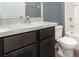 Cozy bathroom with a toilet, tub, and dark wooden cabinets at 15406 Gopher Trop Pl, Sun City Center, FL 33573