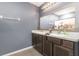 Bathroom vanity with dual sinks, wood cabinets, and a large mirror at 15406 Gopher Trop Pl, Sun City Center, FL 33573