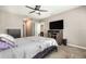 Carpeted bedroom with neutral walls, ceiling fan, television and walk-in closet at 15406 Gopher Trop Pl, Sun City Center, FL 33573