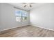 Bright bedroom with wood-look flooring, a large window and a ceiling fan at 15406 Gopher Trop Pl, Sun City Center, FL 33573