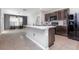 Modern kitchen with dark cabinets, black appliances, central island, and open layout at 15406 Gopher Trop Pl, Sun City Center, FL 33573