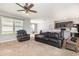 Bright and airy living room featuring carpet, ceiling fan, and open layout connecting to the kitchen area at 15406 Gopher Trop Pl, Sun City Center, FL 33573