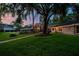 Beautiful backyard featuring lush lawn, mature trees, and patio with outdoor furniture; great for relaxing and entertaining at 16205 Sentry Woods Ct, Odessa, FL 33556