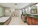 Bathroom with a soaking tub, walk-in shower, marble floors, and and sinks at 16205 Sentry Woods Ct, Odessa, FL 33556