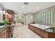 Bright bathroom featuring marble tile floors, a luxurious bathtub, and a large glass block window at 16205 Sentry Woods Ct, Odessa, FL 33556