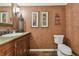 Cozy powder room with a decorative mirror, rustic vanity, and unique patterned wallpaper at 16205 Sentry Woods Ct, Odessa, FL 33556