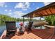 View of a boat lift on a private dock with lounge chairs and a view of the lake under a sunny sky at 16205 Sentry Woods Ct, Odessa, FL 33556