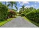 Long, private driveway lined with mature landscaping, leading to a beautiful home at 16205 Sentry Woods Ct, Odessa, FL 33556