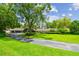 Lush front yard with mature trees and landscaping enhancing this home's curb appeal at 16205 Sentry Woods Ct, Odessa, FL 33556