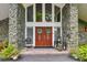 Elegant double front doors framed by stone accents, lush plants, and decorative wreaths at 16205 Sentry Woods Ct, Odessa, FL 33556