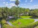 Expansive front yard featuring mature trees, and a circular driveway lined with manicured hedges at 16205 Sentry Woods Ct, Odessa, FL 33556
