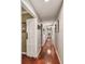 Long hallway with wood flooring, neutral walls, and recessed lighting, ideal for showcasing art at 16205 Sentry Woods Ct, Odessa, FL 33556
