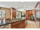 Open concept kitchen with island, granite countertops, stainless steel appliances, and custom cabinets, ideal for entertaining guests at 16205 Sentry Woods Ct, Odessa, FL 33556