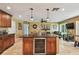 Stylish kitchen island with beverage cooler, granite countertops, and pendant lighting, flowing into the adjacent living area at 16205 Sentry Woods Ct, Odessa, FL 33556