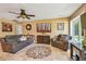 Cozy living room with neutral tones, a ceiling fan, tile floors, and comfortable seating arrangement, ideal for relaxation at 16205 Sentry Woods Ct, Odessa, FL 33556
