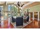 Bright living room features high ceilings, wooden floors, a fireplace, and floor-to-ceiling windows with lake views at 16205 Sentry Woods Ct, Odessa, FL 33556
