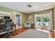 Office with wooden floors, a desk, and sliding glass doors overlooking the backyard and pool at 16205 Sentry Woods Ct, Odessa, FL 33556