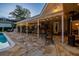 Outdoor patio with a built-in bar, barbeque, seating area, and a charming, rustic stone patio, perfect for entertaining at 16205 Sentry Woods Ct, Odessa, FL 33556