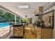 Outdoor kitchen with granite counters, stainless steel grill, bar seating, and ample storage at 16205 Sentry Woods Ct, Odessa, FL 33556